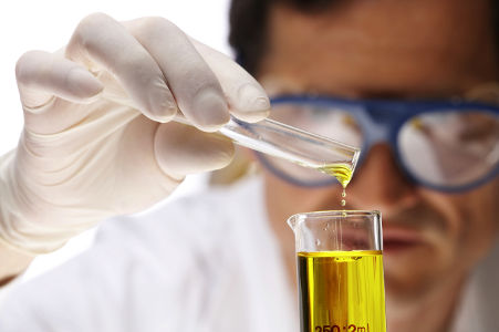 man in white coat pouring yellow liquid with into a glass