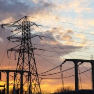 Silhouette of pylon and substation against a warm sunset sky. High Quality Image