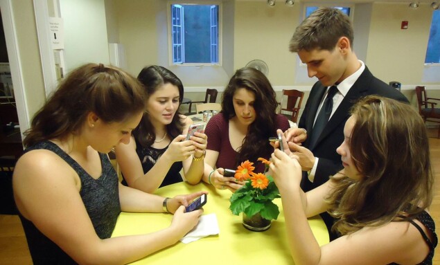 Young_people_texting_on_smartphones_using_thumbs